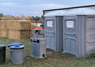 Two wheelchair-accessible porta potty rentals with a handwashing station rental in front of them.