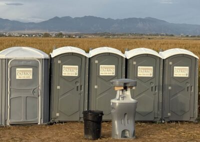 A row of standards and one handicap porta potty rentals with a handwashing station rental in front of them.