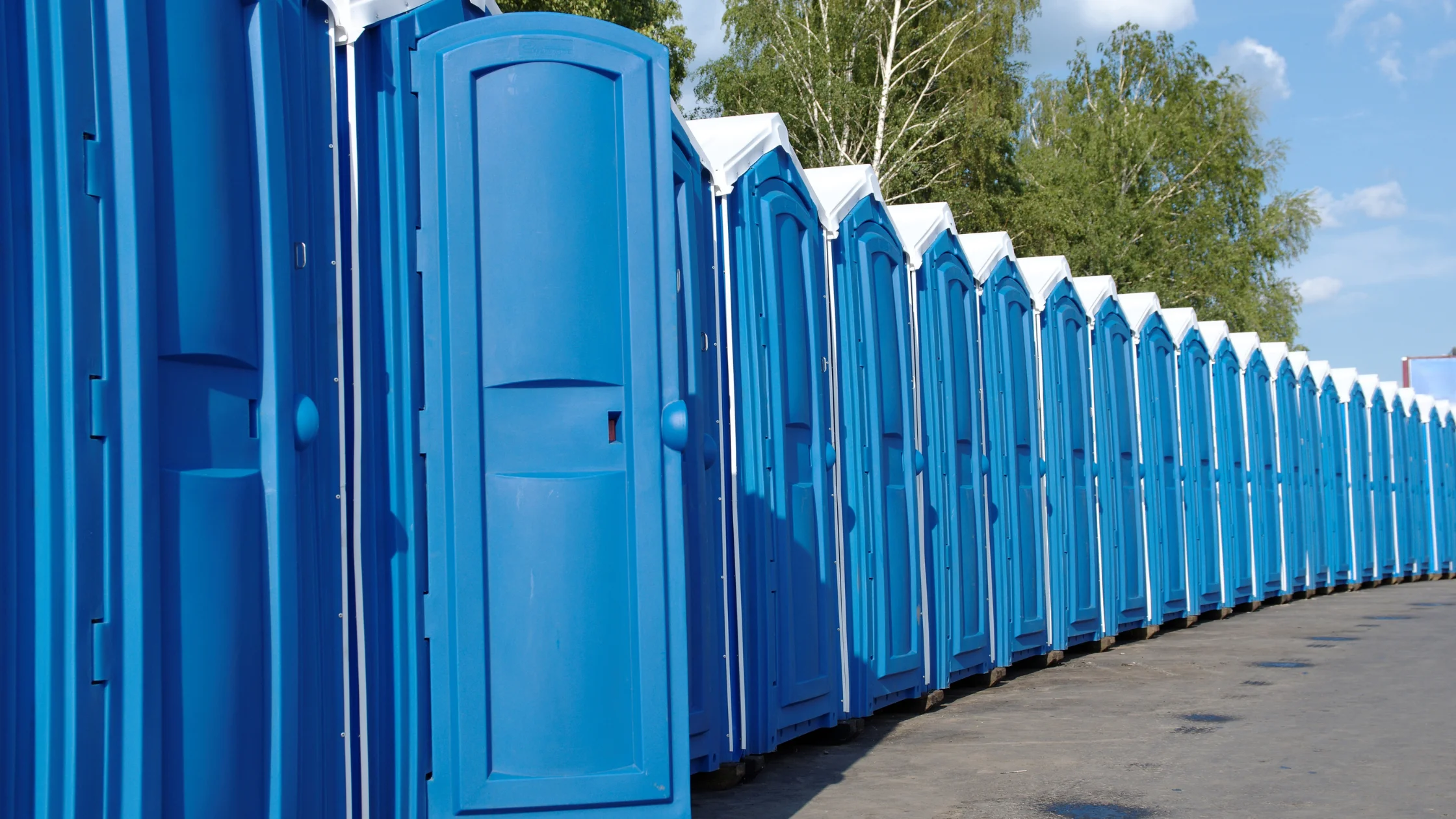 Best porta potty rental in Midland TX blue portable toilet units arranged at outdoor event site.